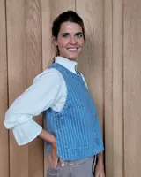 Chaleco de corte recto y largo a la cintura, confeccionado en denim con estampado de rayas verticales en tonos azul y blanco. Presenta cuello redondo y costuras visibles que definen su estructura.