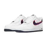 Championes Nike Air Force 1 '07 de corte bajo, color blanco con detalles en azul marino y rojo. Presentan el icónico diseño de la silueta con perforaciones en la puntera, suela de goma con tecnología Air y un gráfico de mano en el talón.