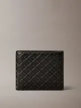 Billetera plegable de cuero negro con diseño de monograma grabado en toda la superficie. Cuenta con monedero interior, compartimento para billetes y múltiples ranuras para tarjetas.
