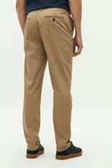 Pantalón chino de corte regular, confeccionado en tejido de algodón con elastano. Presenta cierre frontal con botón y cremallera, bolsillos laterales y traseros, y trabillas para cinturón.