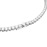 Conjunto de collar y aros plateados con circonitas blancas. El collar es una cadena integral de piedras brillantes y los aros son pequeños botones.