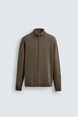 Chaqueta de punto de algodón con corte regular, cuello perkins y cierre frontal con cremallera. Presenta mangas largas con puños acanalados y terminaciones en rib.