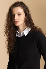 Cardigan negro de tejido suave y liviano, con cierre frontal abotonado y cuello redondo.