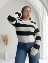 Sweater de punto a rayas horizontales anchas en blanco y negro, con cuello redondo y mangas largas.