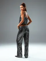 Pantalón largo de lentejuelas negras, de corte palazzo.