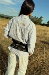 Cinturón ancho tipo corset confeccionado en cuero genuino, con diseño fruncido y cierre frontal mediante hebilla metálica.