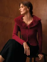 Cardigan de tejido acanalado color bordó, con cuello de piel sintética al tono, cierre frontal con botones y diseño entallado de manga larga.