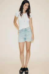 Bermuda de tiro alto confeccionada en denim, con diseño de cinco bolsillos, trabillas para cinturón y bajo con dobladillo vuelto.
