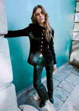 Pantalón flare de tiro bajo con efecto cuero, color verde oscuro, de corte entallado y diseño largo con cierre de gancho y cremallera.