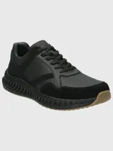 Sneaker urbana de hombre con diseño técnico, confeccionada en una combinación de cuero liso y gamuza. Presenta una suela con tecnología Spinal que ofrece amortiguación y retorno de energía, con base de goma para mayor tracción y estabilidad.