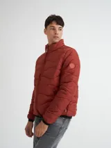 Campera capitoneada color ladrillo, con cuello alto, cierre frontal y bolsillos laterales con cierre.