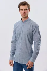 Camisa de lino y algodón color blanco, con cuello mao, manga larga y cierre frontal de botones. Presenta un pequeño logo bordado en el pecho.