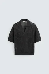 Polo de manga corta confeccionado en tejido de punto calado con estructura abierta. Presenta un diseño de corte relajado, cuello solapa con abertura frontal en pico y terminaciones acanaladas en puños y bajo.