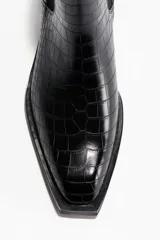 Botas Chelsea de caña media con acabado efecto piel de cocodrilo. Presentan elásticos laterales, punta cuadrada y trabilla trasera para facilitar el calce, con un taco bajo y bloque.