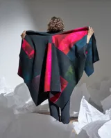 Ruana confeccionada en lana merino afieltrada, con diseño geométrico multicolor inspirado en los cultivos del campo.