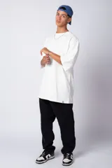 Remera de corte oversize, color blanco, con cuello redondo y mangas cortas amplias, confeccionada en algodón.