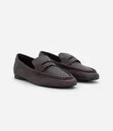 Mocasín femenino estilo penny loafer confeccionado en cuero, con suela baja y diseño estructurado con recorte en el empeine.