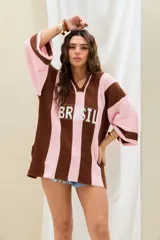Remerón de punto oversize con diseño de rayas verticales en tonos marrón y rosado, cuello en V y moldería amplia. Presenta la inscripción "BRASIL" estampada en el frente.