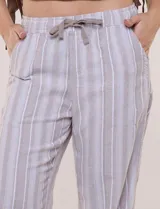 Pantalón de lino de calce holgado y caída ligera, con estampado de rayas verticales en tonos celestes y blancos. Cuenta con cintura elastizada fruncida con cordón ajustable al frente, bolsillos laterales y pierna recta.