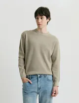 Sweater de punto con textura tipo waffle, cuello redondo y mangas largas con puños acanalados.