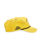 Gorra tipo trucker color amarillo con bordado frontal que incluye la frase 'TWOJEYS' y la silueta de un caballo. Presenta un cordón decorativo negro en la base de la visera y el texto 'CITY COWBOYS' bordado en el lateral.