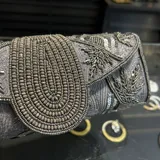 Sobre de fiesta dorado con bordado de mostacillas y lentejuelas. Tiene asa de cadena dorada para colgar al hombro.