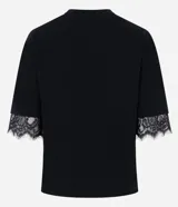 Remera de corte recto y calce confortable, confeccionada en algodón. Presenta cuello redondo y mangas cortas amplias con delicada aplicación de encaje en los bordes.
