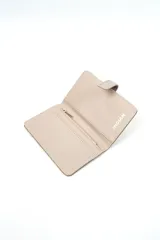 Billetera compacta de cuerina color bordó con textura granulada, solapa de cierre con broche magnético en tono marrón y costuras decorativas contrastantes.