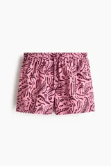 Short de baño rosado con estampado tropical en tono bordó, elástico revestido y cordón ajustable en la cintura, bolsillos laterales y suspensor interior de malla.