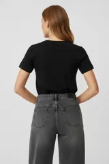 Remera de algodón blanca de manga corta y corte holgado, con cuello redondo a la base y apliques de flores bordadas con lentejuelas en el frente.