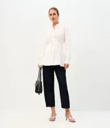 Pantalón de jean con corte new carrot, de cintura alta y estructura firme. Presenta un diseño holgado en la cadera que se estrecha hacia el bajo, con bolsillos funcionales y cierre frontal con botón y cremallera.