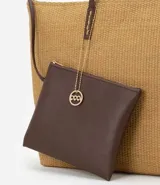 Bolso de playa mediano de fibra de papel color marrón claro, con asas de hombro pespunteadas en marrón oscuro. Incluye un neceser con cierre.