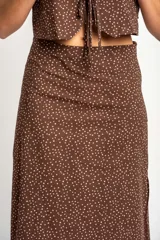 Falda midi de corte recto, color marrón con estampado de lunares pequeños en tono claro. Presenta un diseño de tiro alto y largo hasta la pantorrilla.