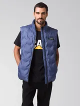 Chaleco puffer Caterpillar color azul, con cuello alto, cierre frontal y parches de la marca en el pecho.