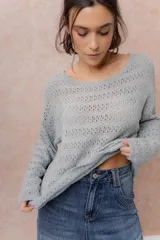 Sweater tejido calado color beige, con escote amplio y mangas largas de calce relajado.