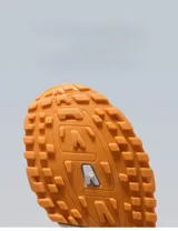 Zapatillas deportivas de mujer, estilo retro running, en tonos blanco y gris claro. Presentan una combinación de malla transpirable y paneles de gamuza sintética. La suela es gruesa y blanca, con una suela exterior de goma color caramelo. Detalle en el talón en color marrón.