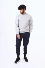 Pantalón de felpa con cintura elástica ajustable mediante cordón, bolsillos laterales y puños acanalados en los tobillos.