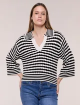 Blusa tejida de punto a rayas horizontales blancas y negras, con cuello polo y escote en V profundo. Presenta hombros caídos, mangas 3/4 estilo campana y corte holgado.