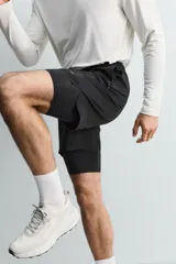 Pantalones cortos de entrenamiento 2 en 1 de color marrón, confeccionados por Zara Athleticz en tejido técnico ligero y elástico con malla interior. Cuenta con cintura elástica ajustable con cordón y bolsillos laterales.