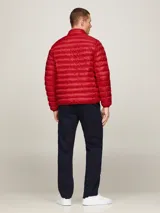 Campera acolchada roja de poliéster reciclado, con cuello alto, cierre de cremallera, bolsillos laterales y logo de Tommy Hilfiger bordado en el pecho.