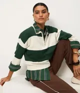 Suéter de punto color verde oscuro y blanco, con cuello polo, cierre frontal parcial de cremallera metálica y mangas largas con puños. Presenta un estampado de rayas horizontales.