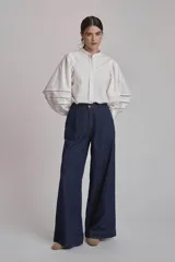 Camisa blanca de mangas largas abullonadas con detalles de calado en los puños y cuello mao.