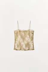 Top de tirantes finos con escote recto, confeccionado en tejido de encaje semitransparente con hilo metalizado dorado.