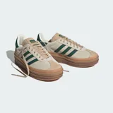 Championes Adidas Gazelle Bold color beige con las tres tiras clásicas en verde oscuro y suela de goma marrón con plataforma.