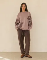 Buzo de punto amplio y relajado, color rosado con diseño floral en tonos marrones. Posee cuello redondo alto y terminaciones acanaladas en cuello, puños y ruedo.