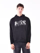 Buzo hoodie negro con cordones ajustables y bolsillo tipo canguro. Estampado frontal con diseño de montañas y texto 'Restless. Explore More'.