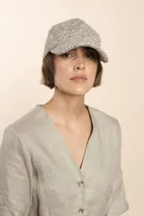 Gorra con visera confeccionada en lana fina sin teñir, con un sutil patrón de tejido en espiga.