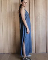 Vestido largo azul melange de corte imperio, con escote en V y breteles finos. Presenta tajo lateral en la falda.