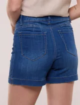 Short de jean azul de tiro medio y calce cómodo con elasticidad, con pretina, pasadores, bolsillos y ruedo con dobladillo ancho.