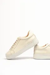 Zapatillas color beige claro, con capellada de cuero suave y acolchado, forro y plantilla de cuero vacuno, y suela de EVA. Tienen una plataforma de 3.8 cm en la parte trasera y 3.2 cm en la delantera.